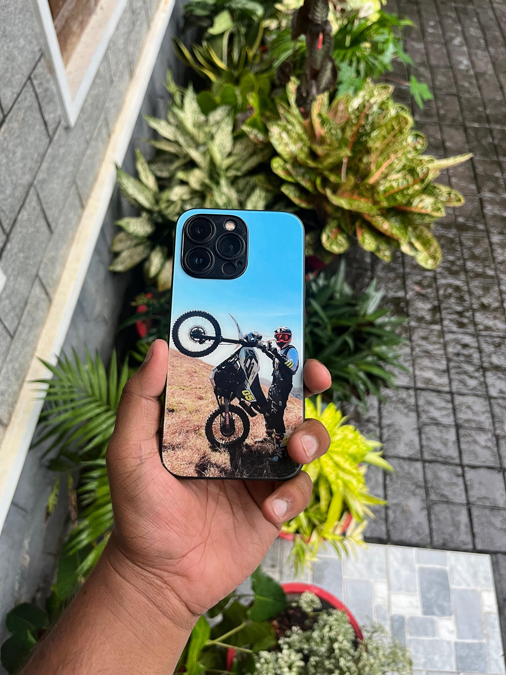 Blue motorcycle design on a phone case held outdoors